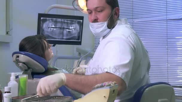 Diş hekimi hastayla çalışır ve araçlarını kullanır — Stok video