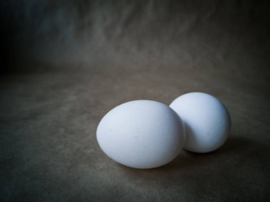 Çiğ tavuk yumurtalarının yakından görüntüsü. Koyu arkaplanda yumurtalar