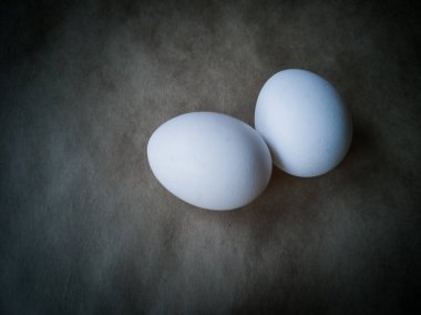 Çiğ tavuk yumurtalarının yakından görüntüsü. Koyu arkaplanda yumurtalar