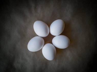 Çiğ tavuk yumurtalarının yakından görüntüsü. Koyu arkaplanda yumurtalar