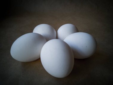 Çiğ tavuk yumurtalarının yakından görüntüsü. Koyu arkaplanda yumurtalar