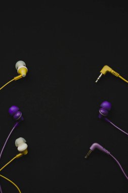  Yellow and purple headphones on black background