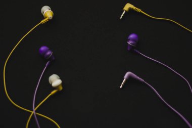  Yellow and purple headphones on black background