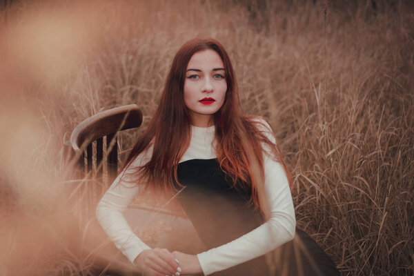 Portrait of a beautiful redhead girl in a field