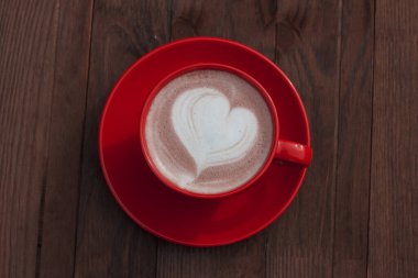 Tahtanın üzerinde kırmızı bir fincan kakao.