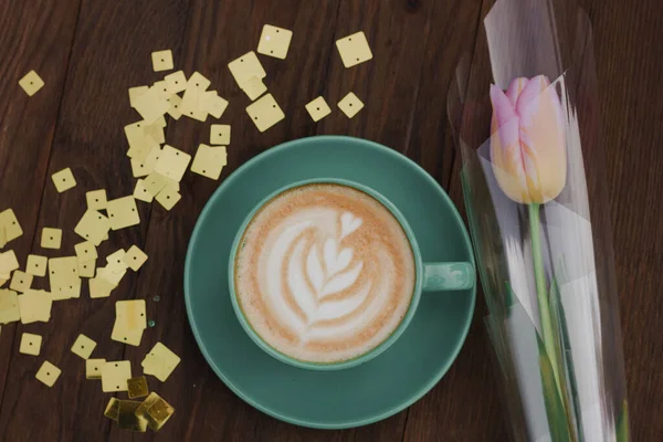 Koffie Een Groene Beker Met Een Roze Tulp Een Houten — Stockfoto