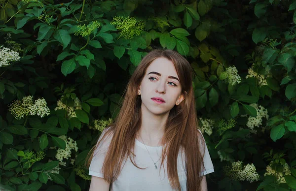 Schöne Nachdenkliche Mädchen Auf Einem Hintergrund Aus Grünen Blättern — Stockfoto