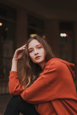 Turuncu kapüşonlu güzel bir kadının portresi. Model pozu