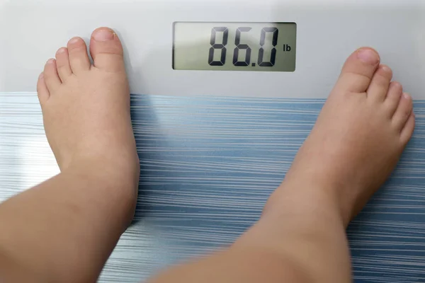Дети с избыточным весом, весами — стоковое фото