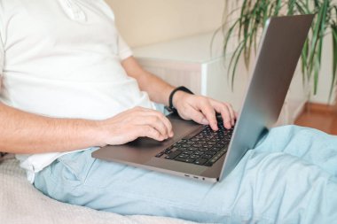  Evde dizüstü bilgisayar kullanan, evde çalışan, rahat bir iş yerinde çalışan, karantina sırasında evden çalışan bir adam. Coronavirus konsepti
