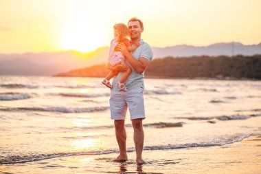  Baba ve küçük kızı tatilde sahilde yürüyorlar, konsept mutlu babalar günü, mesaj için yer.