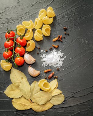 Domates, kiraz, defne ve biraz daha baharatlı makarna kabuğu pişirmek için gerekli malzemeler. Sağlıklı gıda konsepti. 