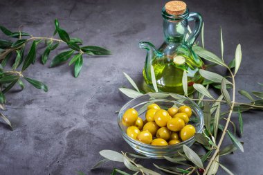 Cam bir kasede zeytinyağı ve koyu bir sırtüstü zeytinyağı.