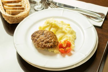 Kızarmış pirzola, patates püresi ve kırmızı taze domates.