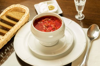 Kırmızı sebze çorbası beyaz kasede servis ediliyor. 