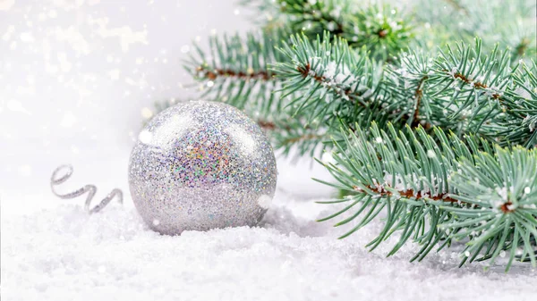 Silberne runde Weihnachts- und Neujahrskugel auf dem weißen Schnee bac — Stockfoto