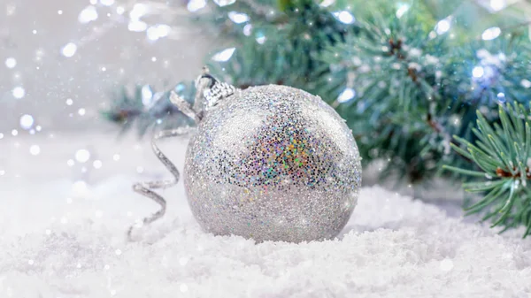 Silberne runde Weihnachts- und Neujahrskugel auf dem schneeweißen Bac — Stockfoto