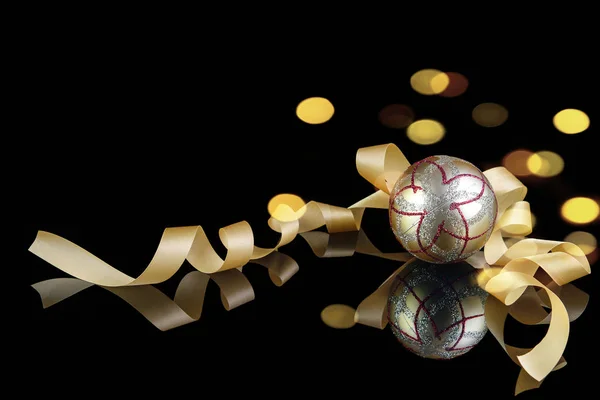 Goldener Weihnachts- und Neujahrsball mit goldener Schleife und Bokeh — Stockfoto