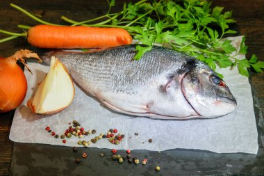 Koyu arka planda Dorada taze balık pişirmeye hazır.