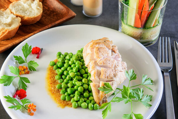 Жареная куриная грудка с зеленым жареным горохом на белом празднике
