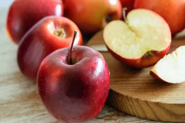 Grupo de manzanas frescas rojas enteras y cortadas en la ba natural de madera — Foto de Stock