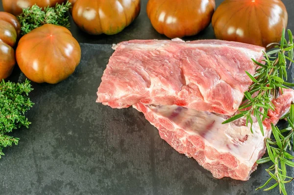 Pişmemiş taze domuz pirzolası, domatesle pişirilmeye hazır. 