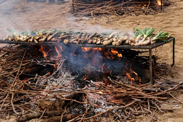 Barbecue à l'oignon de printemps sur le barbecue en métal sur le marché , — Photo
