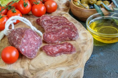 Dilimlenmiş taze et, domates, kiraz, zeytinyağı ve zeytin yakın plan. Taze ve sağlıklı Akdeniz yemekleri.. 