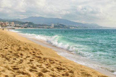 Akdeniz manzarası. Dalgaları, kumları ve bulutlu gökyüzüyle mavi Akdeniz. Peyzaj ve seyahat kavramı. 