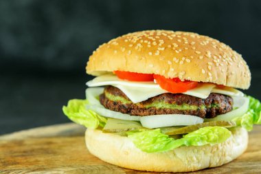 Tahta arka planda ıspanak pirzolası ve sebzeli vejetaryen hamburger izole edilmiş. Vejetaryenler için lezzetli hafif burger..