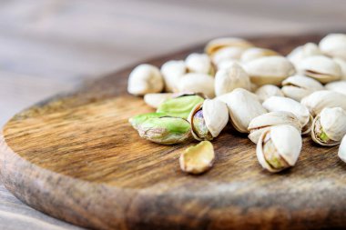 Ahşap mutfak arka planında bir grup fıstık var. Yakın plan. Sağlıklı ketojenik diyet fıstığı. 