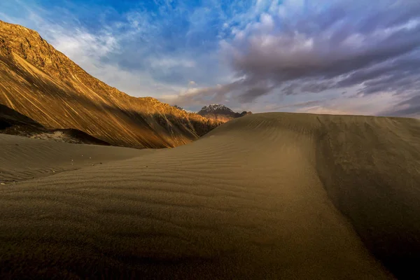 Zandduinen tegen de achtergrond van verre kleurrijke berg r — Stockfoto