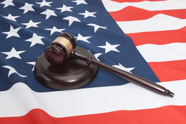 Studio shot of judge gavel and soundboard laying over USA flag — Stock Photo, Image