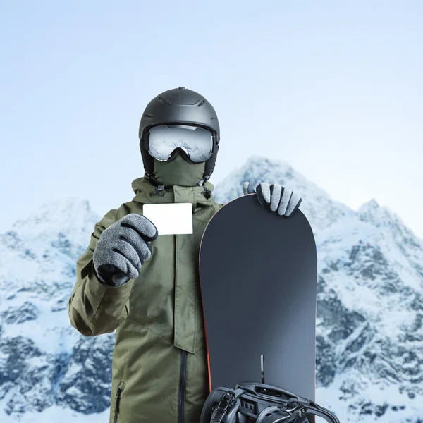 Joven snowboarder con forfait en blanco con la montaña en el fondo —  Fotos de Stock