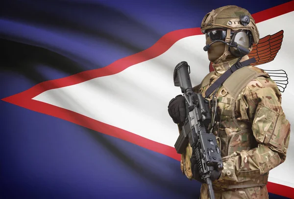 Soldat i hjälm holding kulspruta med flagga på bakgrunden-serien - Amerikanska Samoa — Stockfoto