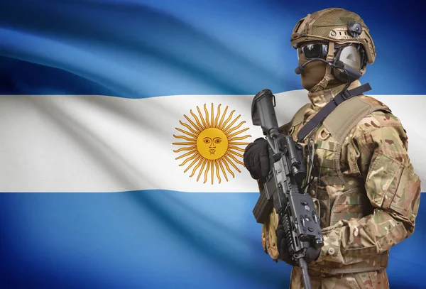 Солдат в шлеме, держа пистолет с флагом на фоне серии - Аргентина — стоковое фото