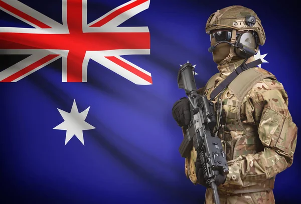 Soldat i hjälm holding kulspruta med flagga på bakgrunden-serien - Australien — Stockfoto