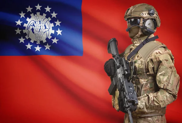 Soldat i hjälm holding kulspruta med flagga på bakgrunden-serien - Burma — Stockfoto