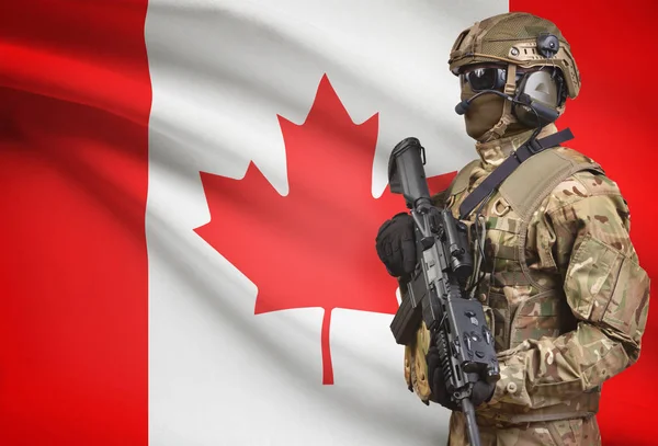 Στρατιώτης στο κράνος, κρατώντας πολυβόλο με σημαία στο φόντο σειρά - Καναδάς — Φωτογραφία Αρχείου