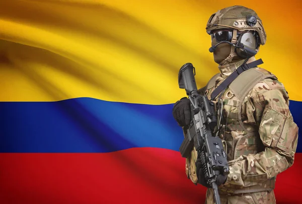 Katona sisak gazdaság géppuska zászló a háttérben sorozat - Kolumbia — Stock Fotó
