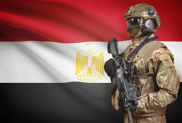 Солдат в шлеме, держа пистолет с флагом на фоне серии - Египет — стоковое фото