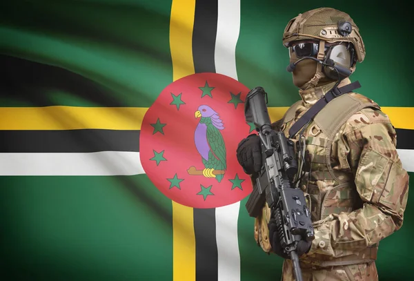 Soldier in helmet holding machine gun with flag on background series - Dominica — Stock Photo, Image