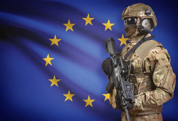 背景シリーズ - 欧州連合の旗と機関銃を保持しているヘルメットの兵士 — ストック写真
