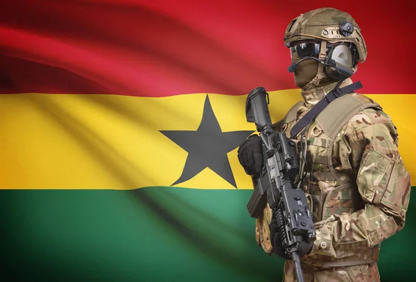 Soldier in helmet holding machine gun with flag on background series - Ghana — Stock Photo, Image