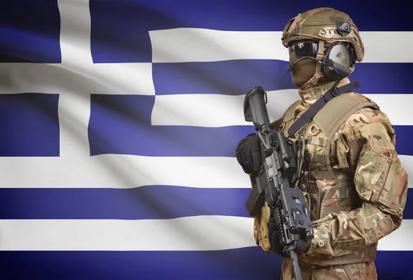 Soldier in helmet holding machine gun with flag on background series - Greece — Stock Photo, Image