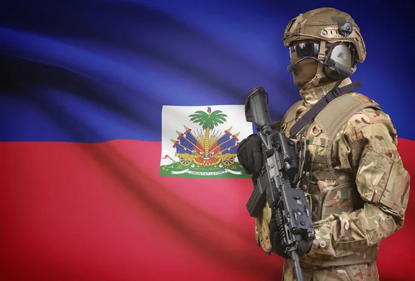 Soldaat in de helm bedrijf machinegeweer met vlag op de achtergrond serie - Haïti — Stockfoto
