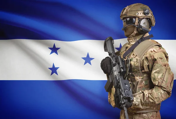 Soldato in casco detenzione machine gun con bandiera sulla serie della priorità bassa - Honduras — Foto Stock