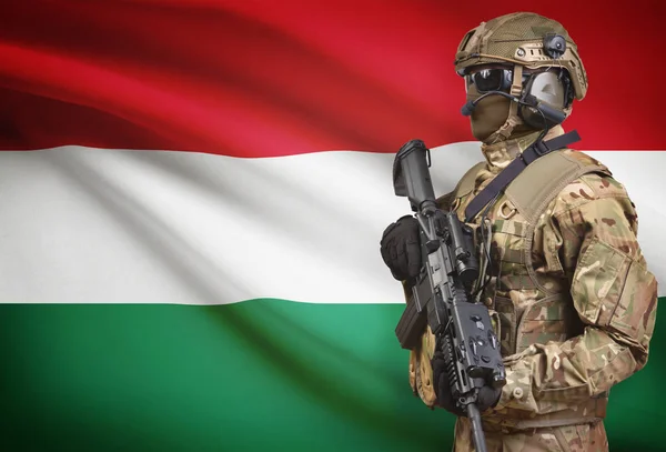 Soldier in helmet holding machine gun with flag on background series - Hungary — Stok Foto