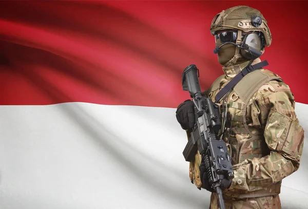 Soldier in helmet holding machine gun with flag on background series - Indonesia — Stock Photo, Image