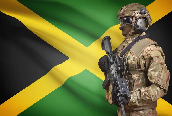 Soldat i hjälm holding kulspruta med flagga på bakgrunden-serien - Jamaica — Stockfoto